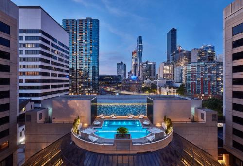 a pool on the roof of a building with a city skyline at Crowne Plaza Melbourne, an IHG Hotel in Melbourne