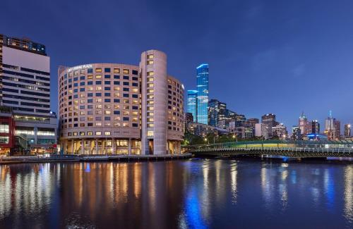 a city skyline with a building and a bridge over a river at Crowne Plaza Melbourne by IHG in Melbourne
