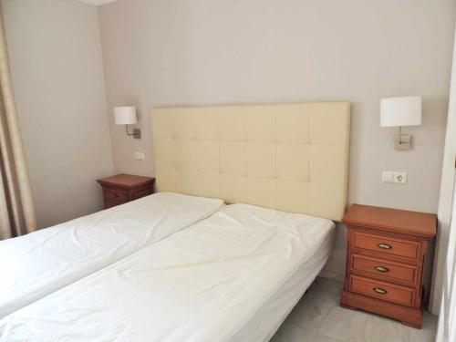 een slaapkamer met een wit bed en 2 nachtkastjes bij Apartamento en Jardines del Puerto in Marbella