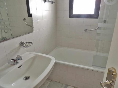 een witte badkamer met een bad en een wastafel bij Apartamento en Jardines del Puerto in Marbella