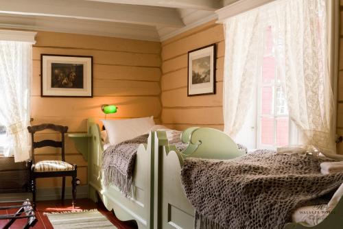 a bedroom with a bed and a chair and a window at Walaker Hotel in Solvorn