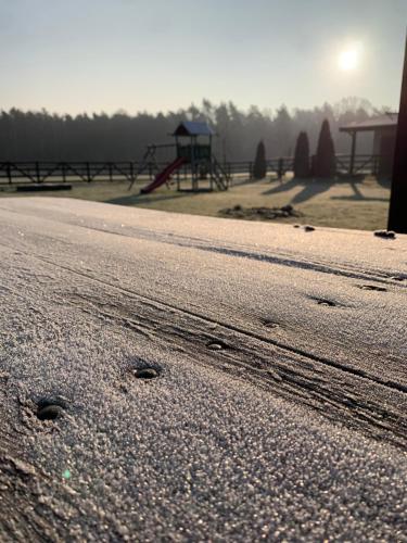 an empty road with a playground in the background at Leśny Zakątek Uroczysko in Rychtal