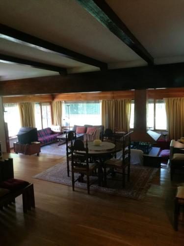 a living room with a table and a couch at Casa Etna in Rascafría