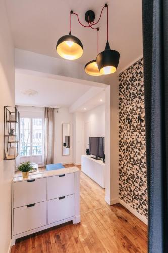 - un salon avec une commode blanche et un mur dans l'établissement LIK APPARTS Gare Rennes - Appart LE HERON, à Rennes