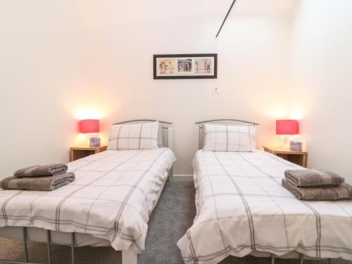 two twin beds in a room with two lamps at 4 Holt Court in Salisbury