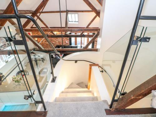 a staircase in a loft with wooden beams at 4 Holt Court in Salisbury