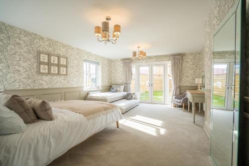 a bedroom with a bed and a desk and a chair at 6 Bedroom New Build Detached House in Bicester in Bicester
