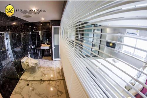 a room with a bathroom with a glass wall at SR Residence Hotel in Phetchabun