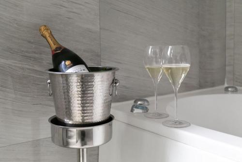 a bottle of champagne in a bucket next to a wine glass at Marconi Hotel in Rende