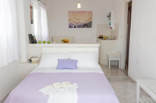 a bedroom with a bed with a purple pillow at Acrothea Suites and Villas in Akrotiri
