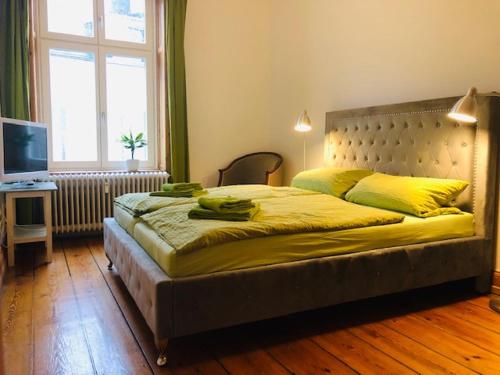 a bedroom with a large bed with yellow sheets at Gästezimmer am Hansaplatz in Hamburg