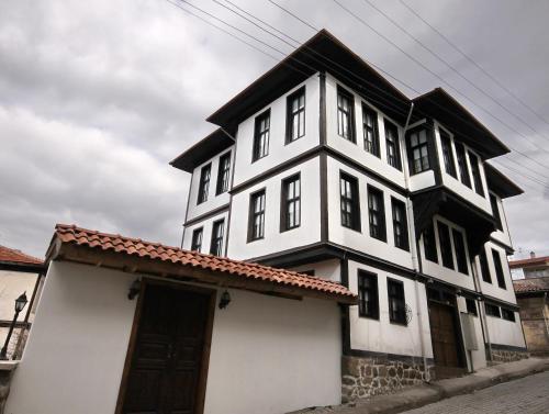 a white and black house with a roof at Kadıoğlu Konağı in Kastamonu