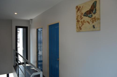 une chambre avec une porte bleue et une photo de papillon dans l'établissement Varinda Hostel, à Bangkok