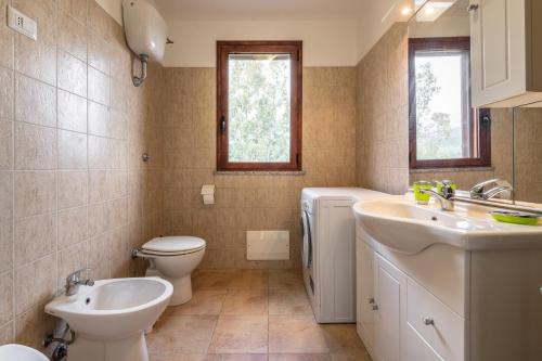 a bathroom with a toilet and a sink and a toilet istg at Villa Giulia Grande in Castiadas