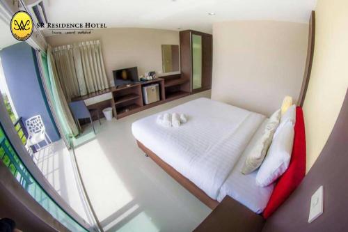 a bedroom with a white bed and a balcony at SR Residence Hotel in Phetchabun