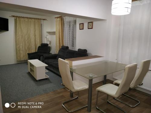Una sala de estar con una mesa y sillas y un sofá. en Apartmány Martina, en Vrchlabí
