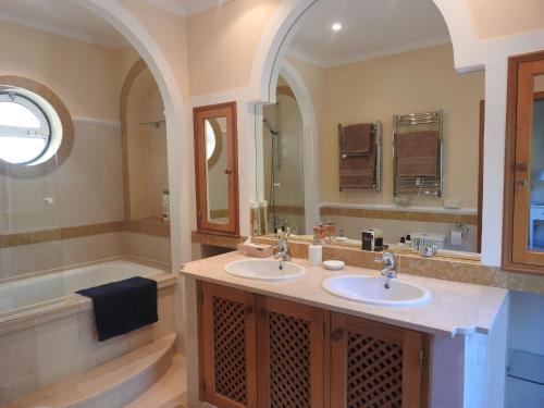 a bathroom with two sinks and a bath tub at Beautiful 2-Bed Villa in Quinta do Lago with Pool in Quinta do Lago