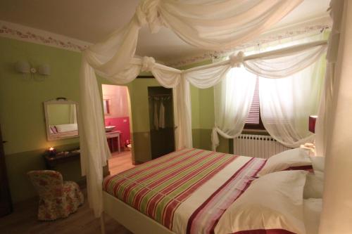 a bedroom with a canopy bed with a window at Podere Osteria in Pienza