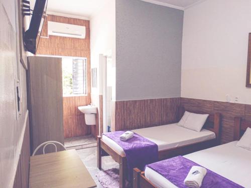 a small room with two beds and a table at Maranim Plaza Hotel in Amparo