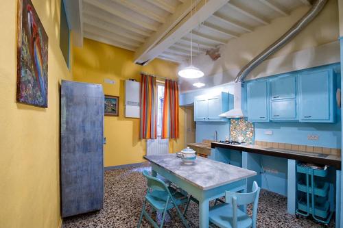 a kitchen with blue cabinets and a table and chairs at Spacious Apartment with City View in Foiano della Chiana 125 m² in Foiano della Chiana