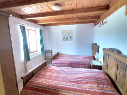 a bedroom with two beds and a window at Appartement de 2 chambres avec jardin amenage et wifi a Soultzeren a 3 km des pistes in Soultzeren