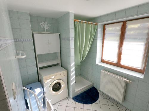 a bathroom with a washing machine and a toilet at Appartement chaleureux à Soultzeren avec vue sur montagne in Soultzeren