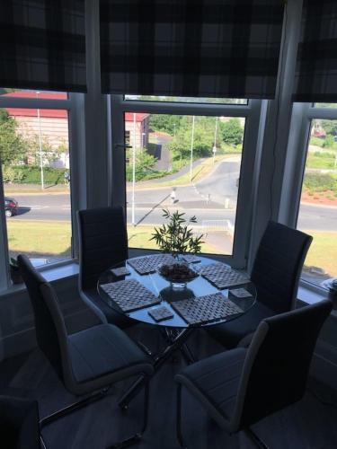 a table and chairs in a room with a window at Lovely 2- Bed Apartment in Hawick in Hawick