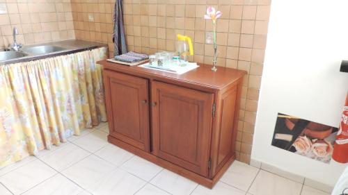 eine Küche mit einem Waschbecken und einem Holzschrank in der Unterkunft Appartement d'une chambre avec wifi a Le Robert a 2 km de la plage in Le Robert