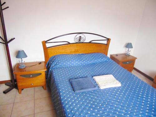 - une chambre avec un lit doté d'un couvre-lit bleu et de 2 tables de nuit dans l'établissement 2 bedrooms house with wifi at Machico 4 km away from the beach, à Machico