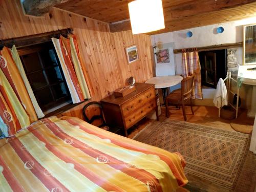 a bedroom with a bed and a desk and a table at Maison confortable en pleine nature près de Vesc avec jacuzzi in Vesc