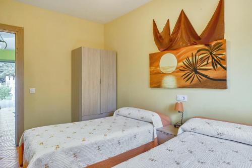 um quarto com duas camas e um quadro na parede em 3 bedrooms villa with city view private pool and jacuzzi at Porzuna em Porzuna