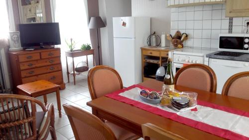 een keuken met een tafel en een keuken met een koelkast bij Maison de 2 chambres a Primelin a 800 m de la plage avec jardin clos et wifi in Primelin