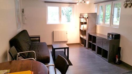 uma sala de estar com um sofá e uma mesa em Studio avec wifi a Saint Ay em Saint-Ay