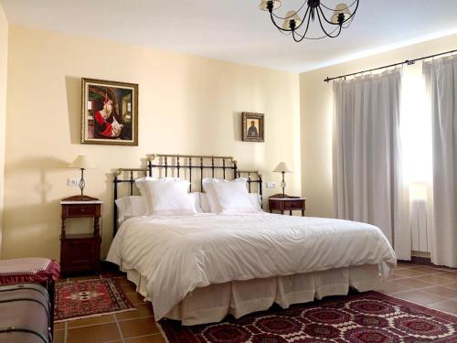 a bedroom with a large bed with white sheets and pillows at 3 bedrooms house with enclosed garden and wifi at Aldehuela de la Boveda in Aldehuela de la Bóveda