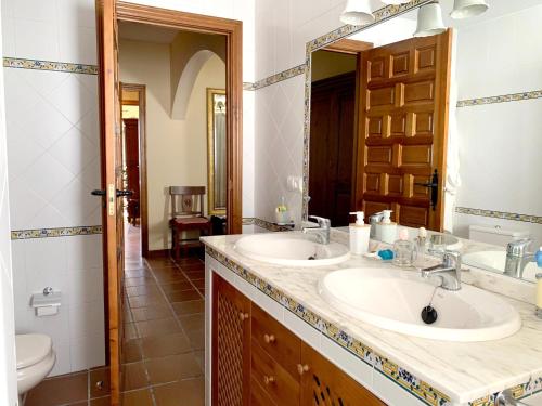 a bathroom with two sinks and a mirror at 3 bedrooms house with enclosed garden and wifi at Aldehuela de la Boveda in Aldehuela de la Bóveda