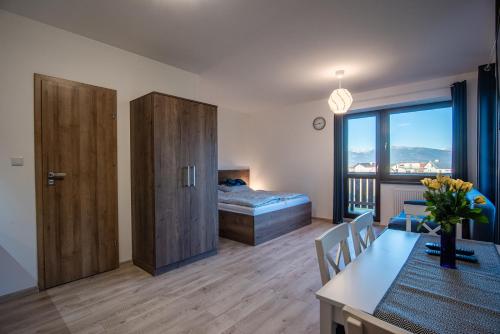een woonkamer met een bed en een eetkamer met een tafel bij Tatry Panorama in Pavčina Lehota