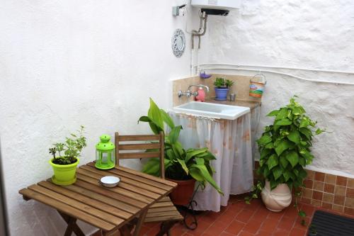 eine Terrasse mit einem Holztisch und einem Waschbecken in der Unterkunft Charming house in Estivella near nature in Estivella