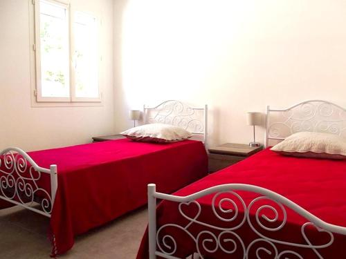 - une chambre avec 2 lits avec des draps rouges et une fenêtre dans l'établissement Maison spacieuse à La Roche-sur-le-Buis avec piscine privée 150 m², à La Roche-sur-le-Buis