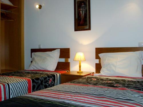 una habitación de hotel con 2 camas y una lámpara en One bedroom apartement with city view shared pool and enclosed garden at Albufeira 2 km away from the beach en Albufeira