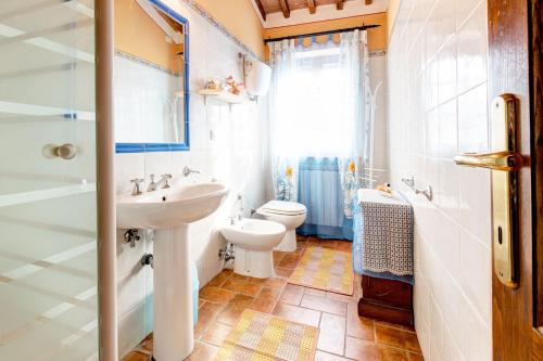 コルトーナにある4 bedrooms villa with city view private pool and enclosed garden at Farnetaのバスルーム(洗面台、トイレ付)、窓が備わります。