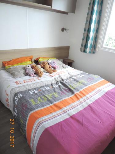 un lit avec des animaux farcis au-dessus dans l'établissement Bungalow Confort Gastes Jacuzzi, à Gastes