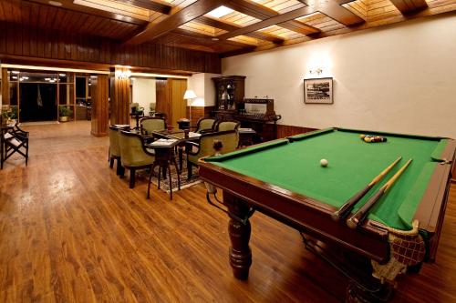 a billiard room with a pool table and chairs at Sinclairs Darjeeling in Darjeeling