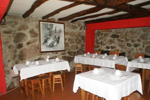 a restaurant with white tables and chairs in a room at Cosy apartment in Seia, 25 sqm, welcoming fireplace in Seia