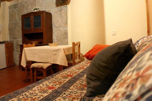 a living room with a table and a couch with a pillow at Cosy apartment in Seia, 25 sqm, welcoming fireplace in Seia