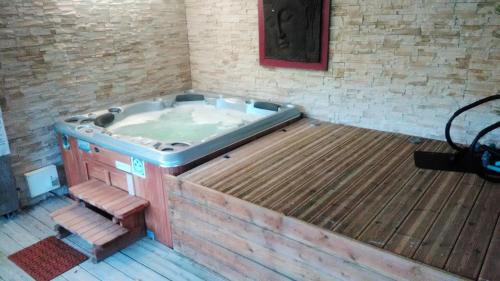 a hot tub in a room with a wooden floor at Villa de 4 chambres avec piscine privee jacuzzi et jardin clos a Chateau la Valliere in Château-la-Vallière