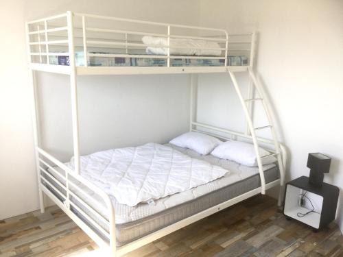- une chambre avec des lits superposés et des bunkitures blanches dans l'établissement Maison confortable à Saint-Hilaire-de-Riez avec jardin clos, à Saint-Hilaire-de-Riez