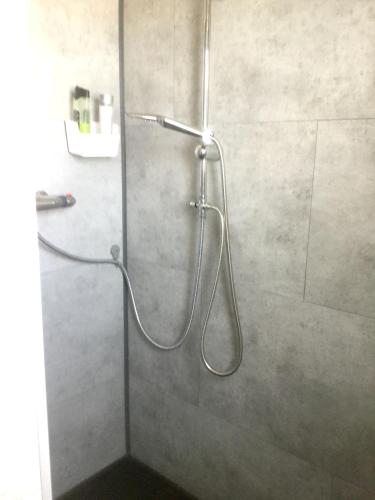 une douche avec un tuyau dans une cabine de douche dans l'établissement Maison confortable à Saint-Hilaire-de-Riez avec jardin clos, à Saint-Hilaire-de-Riez