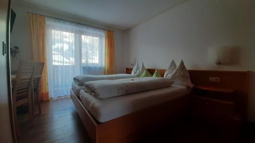 1 dormitorio con 2 camas y ventana grande en Landhaus Sonnrain, en Saalbach Hinterglemm