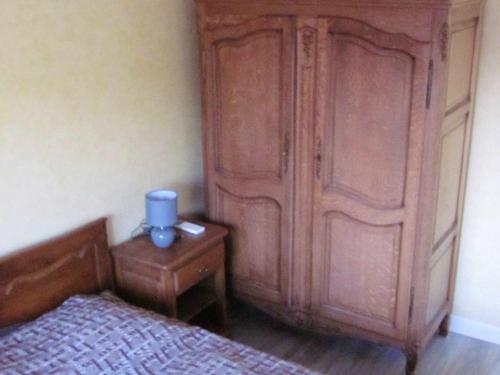 a bedroom with a large wooden cabinet next to a bed at Maison avec spa à They-Sous-Montfort, accueillant et moderne in They-sous-Montfort