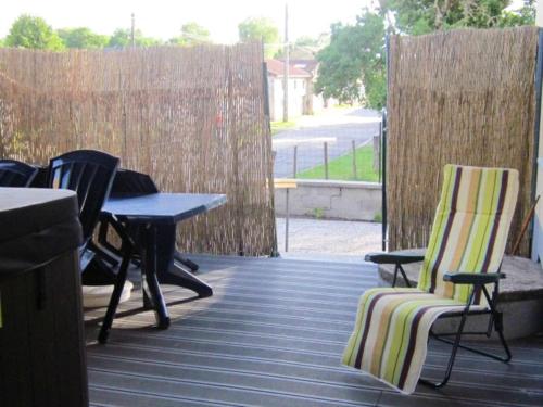 a patio with chairs and a table and a fence at Maison avec spa à They-Sous-Montfort, accueillant et moderne in They-sous-Montfort